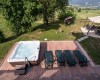 Wanna z hydromasażem i leżaki na tarasie w ogrodzie z widokiem na krajobraz.