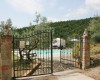 Metalowa brama z widokiem na basen i okoliczny krajobraz.