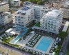 Lotniczy widok na kompleks hotelowy z basenami przy plaży w mieście.