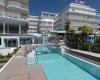 Nowoczesny hotel z odkrytym basenem i palmami.