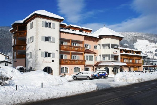 Hotel w zaśnieżonej górskiej scenerii z niebieskim niebem.