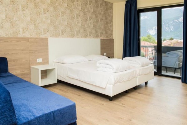 Nowoczesny pokój hotelowy z podwójnym łóżkiem i widokiem na góry.
