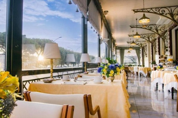 Elegancka restauracja z nakrytymi stołami i widokiem na zewnętrzny krajobraz.