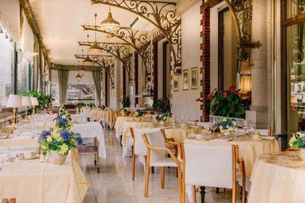 Eleganckie wnętrze restauracji z białymi obrusami i kwiatową dekoracją.
