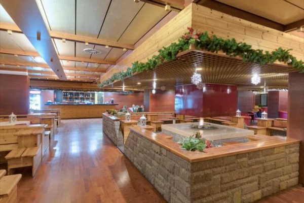 Wnętrze restauracji z drewnianymi meblami i świątecznymi ozdobami.