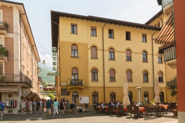Stary hotel z zewnętrzną kawiarnią na placu.