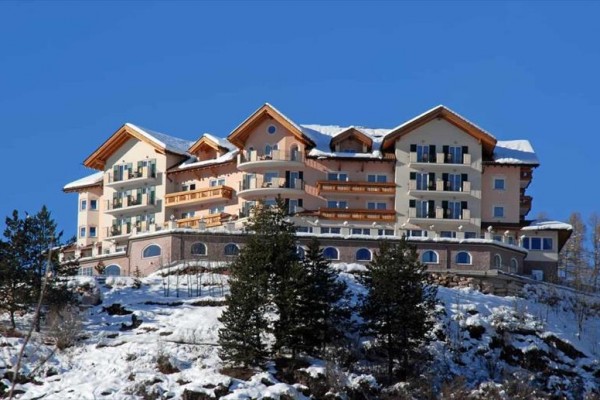 Luksusowy hotel na zaśnieżonym wzgórzu na tle nieba.