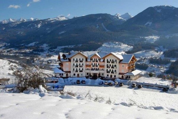 Hotel pośród ośnieżonego górskiego krajobrazu.