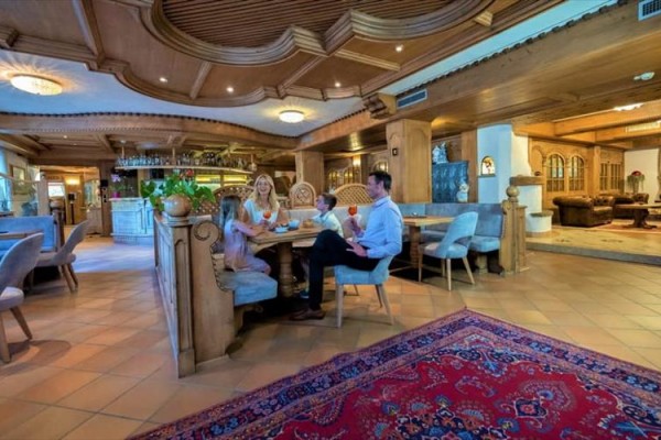 Rodzina przy stole w restauracji z drewnianym wnętrzem.