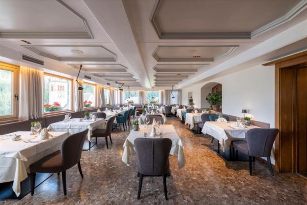 Elegancka restauracja z nakrytymi stołami i nowoczesnym wystrojem.