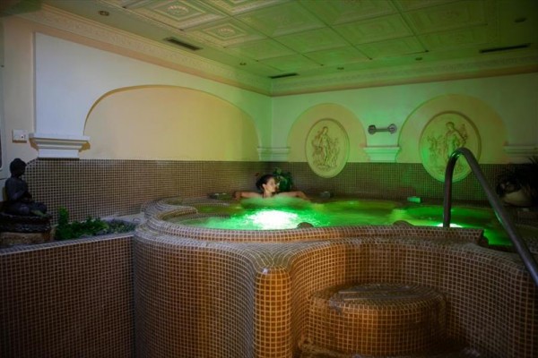 Relaksująca jacuzzi z mozaikowymi płytkami w przytulnie oświetlonym wnętrzu.
