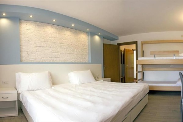 Nowoczesny pokój hotelowy z łóżkiem małżeńskim i łóżkiem piętrowym.