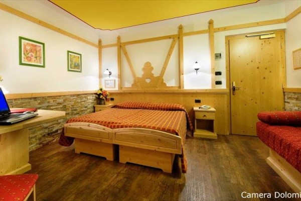 Przytulny pokój hotelowy z drewnianymi meblami i dużym łóżkiem.