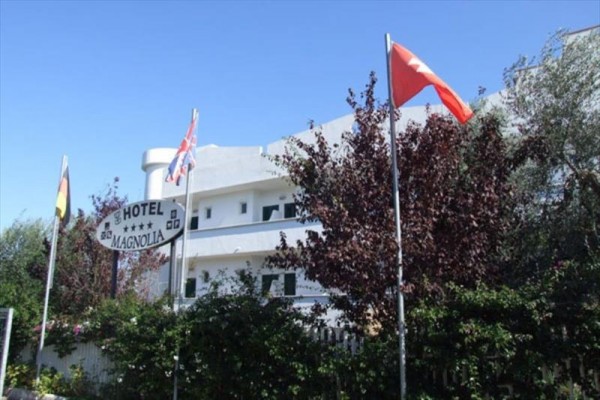 Hotel Magnolia z flagami różnych krajów przed budynkiem.
