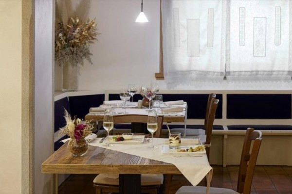Restauracja z nakrytymi stołami, ozdobami i delikatnym oświetleniem.