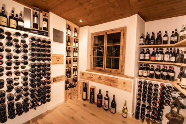 Piwnica na wino z butelkami wina ułożonymi na półkach i stojakach.