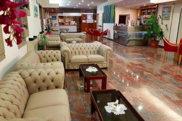 Eleganckie lobby hotelowe z beżowymi sofami i drewnianymi stolikami kawowymi.