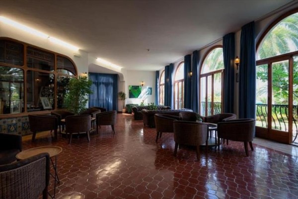 Eleganckie lobby hotelowe z dużymi oknami i wygodnymi fotelami.