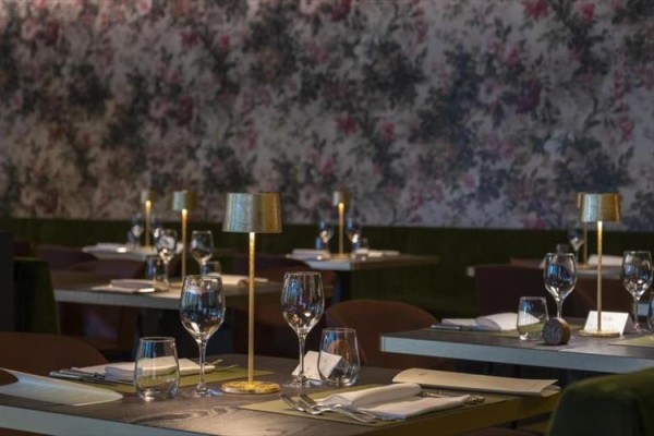 Restauracja z elegancko nakrytymi stołami i delikatnym oświetleniem.