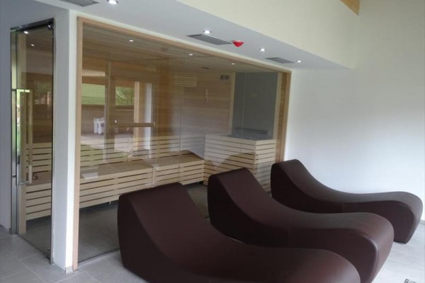 Sauna z trzema brązowymi leżankami do odpoczynku.