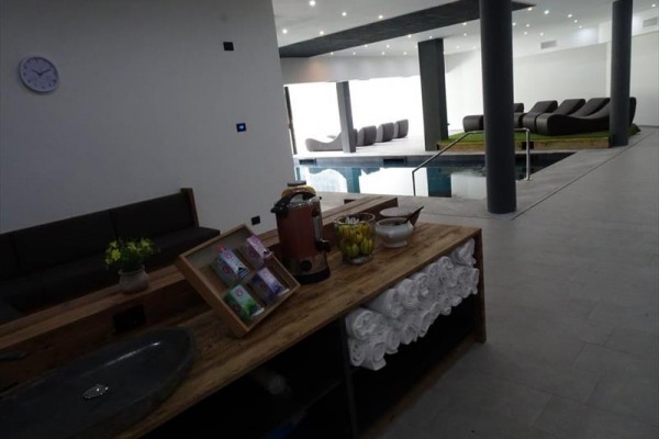 Wnętrze centrum wellness z leżakami relaksacyjnymi i basenem.