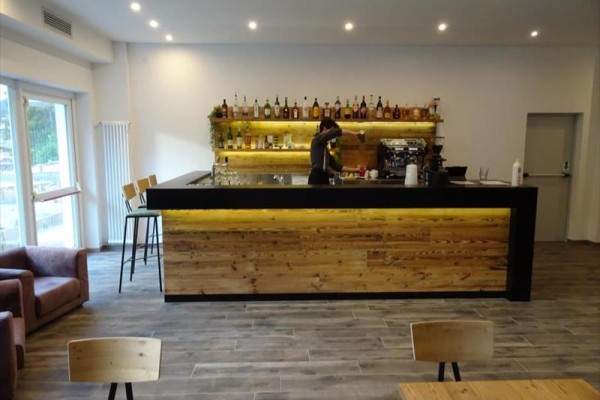 Nowoczesny bar z drewnianym blatem, gdzie personel przygotowuje napój.
