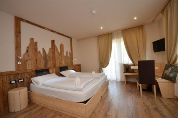 Pokój dwuosobowy w hotelu z drewnianymi meblami i dekoracjami.  