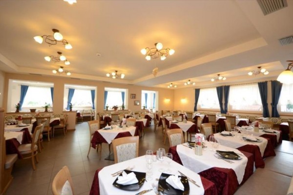 Eleganckie wnętrze restauracji z nakrytymi stołami i zasłonami w oknach.