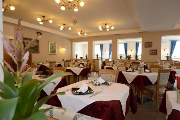 Elegancka restauracja z nakrytymi stołami i dekoracjami w ciepłych kolorach.
