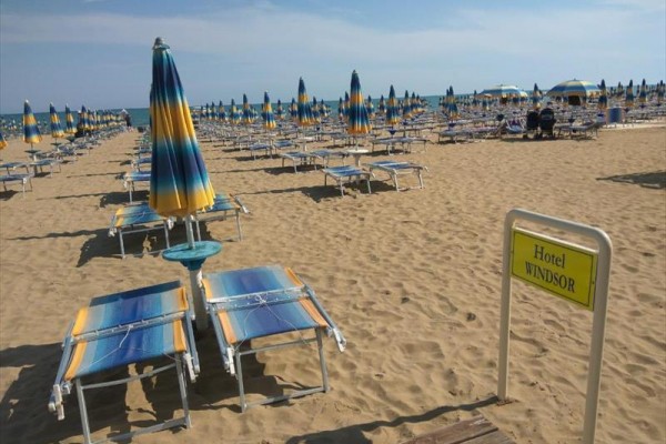Plaża z rzędami leżaków i parasoli z napisem 