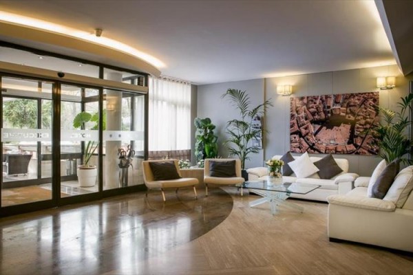 Nowocześnie urządzony hotelowy lobby z wygodnymi fotelami, sofami i roślinami.  