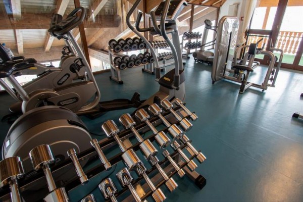 Siłownia z hantlami i sprzętem fitness.