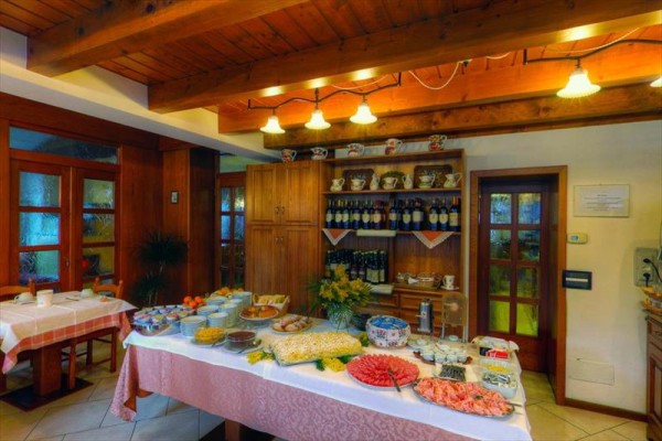 Bogato zastawiony stół z jedzeniem i napojami w restauracji z drewnianym wnętrzem.  