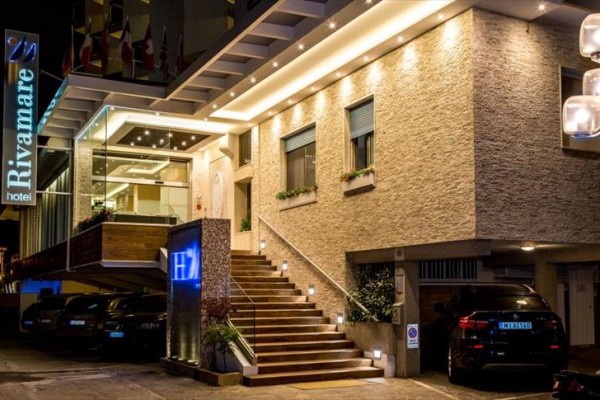 Nocny widok na oświetlone wejście hotelu z napisem 