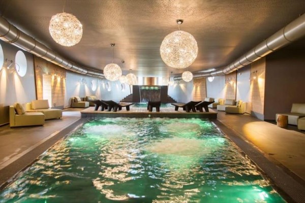 Luksusowe wnętrze spa z jacuzzi i wygodnymi fotelami.