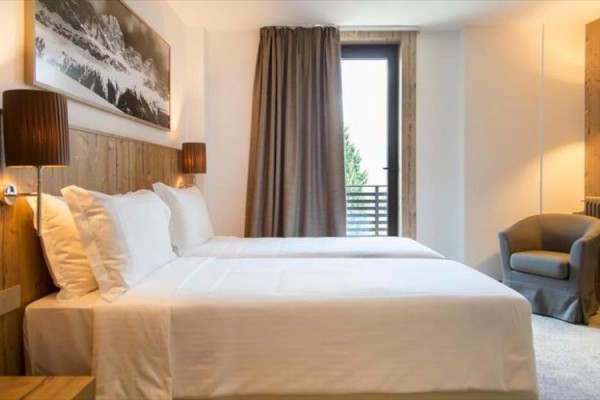 Nowoczesny pokój hotelowy z dwoma łóżkami i obrazem na ścianie.