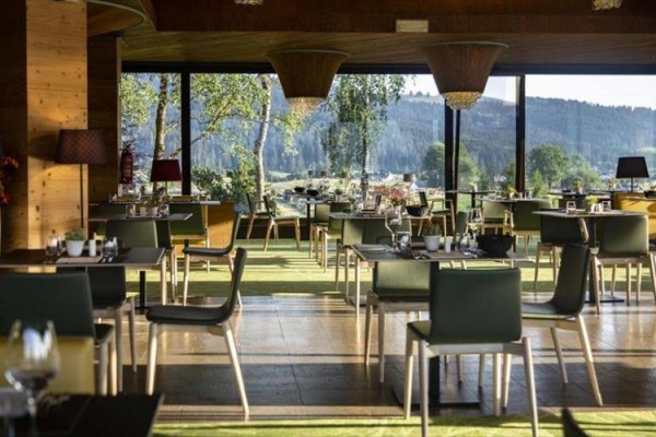 Wnętrze restauracji z widokiem na lasy i góry.