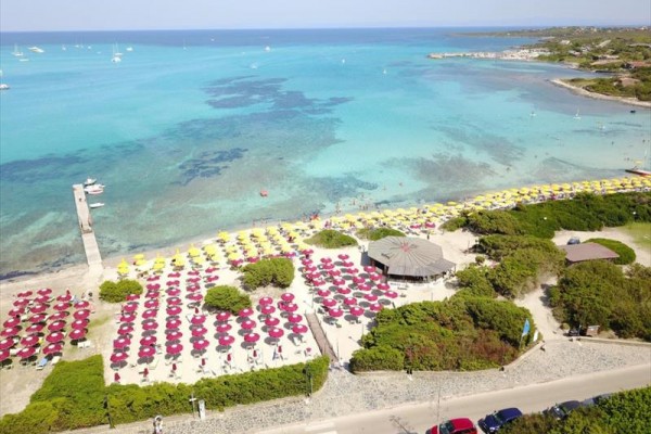 Plaża z kolorowymi parasolami i przejrzystym niebieskim morzem.