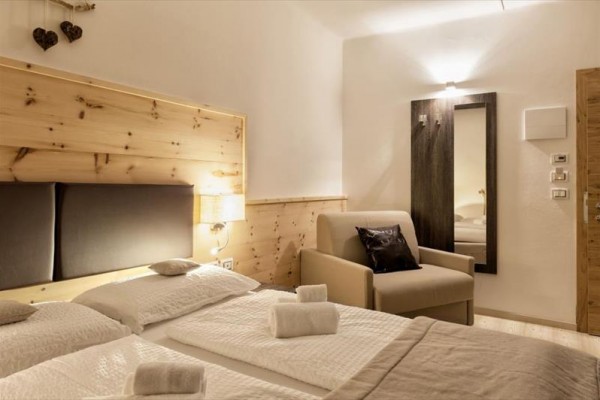 Nowoczesny pokój hotelowy z podwójnym łóżkiem i wygodną sofą.