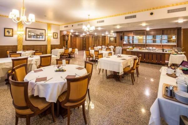 Luksusowa restauracja z drewnianymi meblami i nakrytymi stołami.