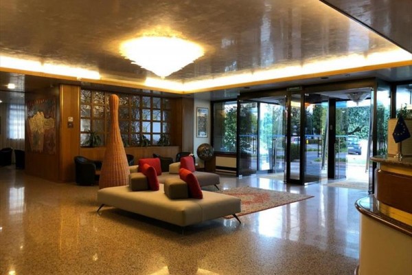 Eleganckie lobby hotelowe z wygodnymi kanapami i szklanymi drzwiami wejściowymi.