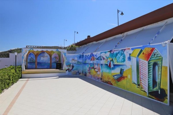 Malowana scena plażowa na zewnętrznej ścianie.