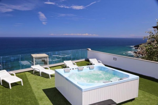 Jacuzzi na tarasie na dachu z widokiem na morze.