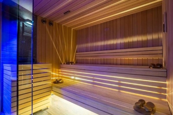 Nowoczesna sauna z drewnianą zabudową i oświetleniem.