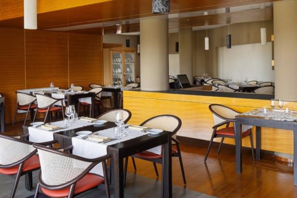 Elegancka restauracja z nakrytymi stolami i nowoczesnym drewnianym wnętrzem.