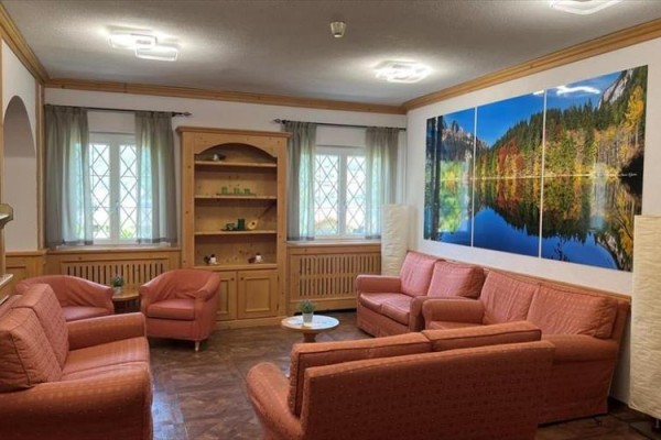 Salon z sofami i obrazem krajobrazu na ścianie.