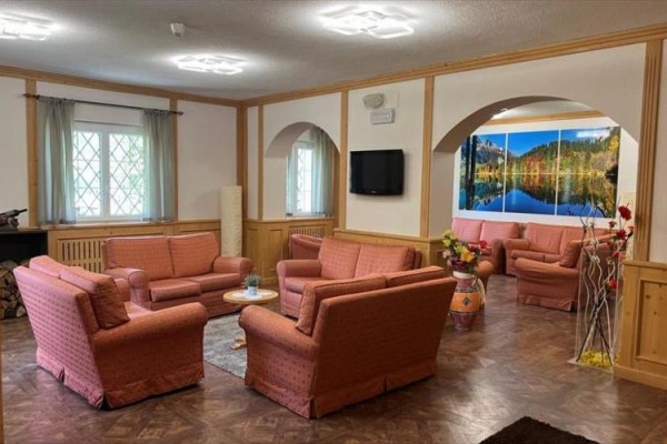 Stylowy salon z wygodnymi sofami i dużym obrazem krajobrazu na ścianie.