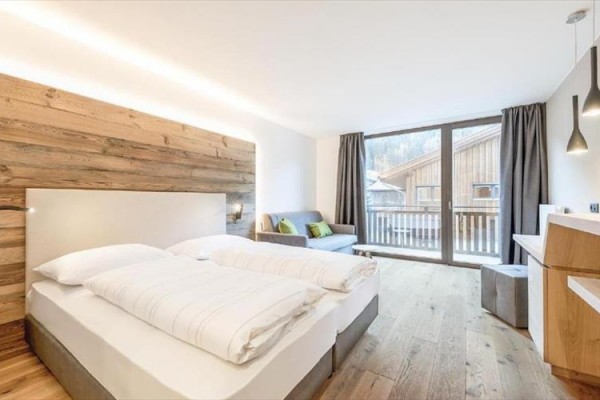 Nowoczesny jasny pokój hotelowy z podwójnym łóżkiem i widokiem na góry.