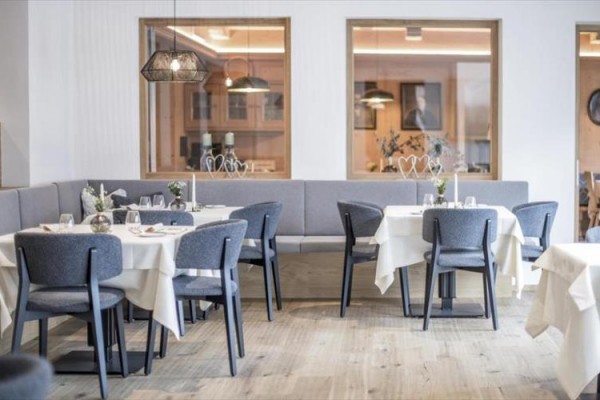 Nowoczesna restauracja z szarymi krzesłami i nakrytymi stołami.