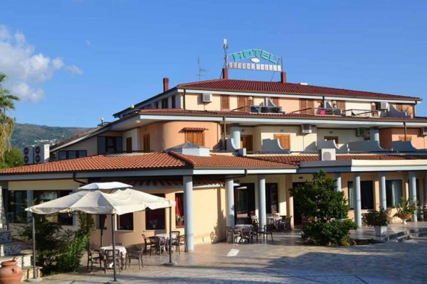 Hotel z tarasem i zewnętrznym miejscem do siedzenia pod parasolami.